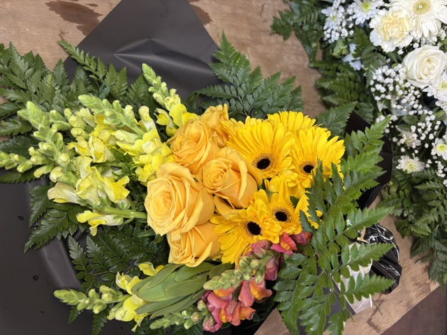 Wrapped market bunch of yellow roses and gerberas